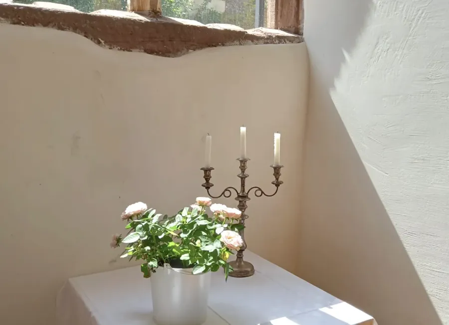 Kerzen und Rosen als Dekoration in der Kapelle der Hochzeitslocation